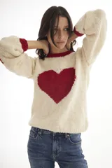 Sweater tejido a mano en Uruguay, color crudo con corazón negro en el frente y detalles en negro en cuello y puños.