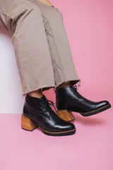 Botines acordonados de cuero negro con tacón de madera.
