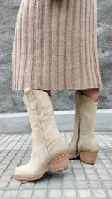 Bota texana de cuero color beige, con caña media, puntera marcada y taco de madera.