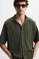 Camisa verde militar de manga corta con cuello bowling, corte relaxed fit y cierre frontal con botones.