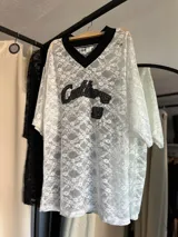 Remerón de encaje negro con mangas 3/4 y cuello camisero.