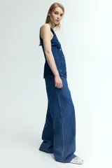 Pantalón de denim azul de corte holgado, con cintura elástica ajustable con cordón, bolsillos laterales y piernas anchas.