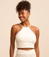 Blusa cropped blanca de encaje con cuello halter, breteles finos con lazo en la espalda y lastex en la espalda.