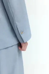 Blazer celeste de doble botonadura con solapas de pico, hombreras finas, bolsillos delanteros ribeteados con solapa y puños abotonados con abertura decorativa. Forrado.