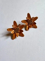 Par de aros con forma de flor color bronce con centro de cuentas marrones.