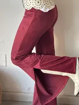 Pantalón de gamuza color borgoña, de corte ajustado y con aberturas en el ruedo.