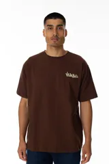 Remera marrón con estampa trasera de un pato con una ametralladora y un maletín lleno de dinero. En la parte superior de la estampa se lee "Vernal" en letras amarillas con estilo graffiti.