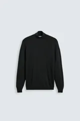 Jersey negro de punto fino con cuello alto y manga larga.