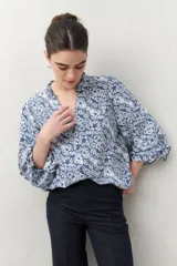 Camisa de manga larga estampada en azul y blanco, confeccionada en viscosa, con cuello mao con pequeño volado y mangas con leve volumen.