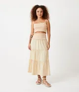Conjunto de top corto con breteles finos y pollera midi de algodón color crema con cintura elastizada y volados en el ruedo.