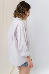 Camisa color crema de algodón liviano, calce oversize, con cuello camisero, cierre abotonado, mangas largas con opción de arremangado y dos bolsillos frontales con solapa.