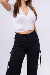 Top negro de punto canalé con cuello tipo chomba, corte cropped y diseño cruzado con abertura en la cintura.