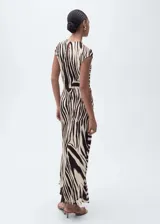 Vestido midi de viscosa con estampado de cebra en tonos beige y marrón. Tiene cuello redondo, manga corta, corte recto y cierre de botón en la parte posterior.