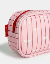 Cartuchera de PU color rosa con estampado de rayas verticales rojas y moños blancos. Tiene cierre superior con tiracierre metálico en forma de moño.