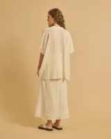 Túnica color crema con mangas anchas, cuerpo acampanado y escote en V.