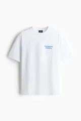 Remera blanca de algodón de peso medio con cuello redondo ribeteado, hombros caídos y bajo recto. Tiene un estampado pequeño en el lado izquierdo del pecho con texto en griego de color celeste. Corte holgado.