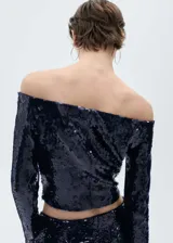 Blusa azul marino con lentejuelas, hombros descubiertos y mangas largas acampanadas.