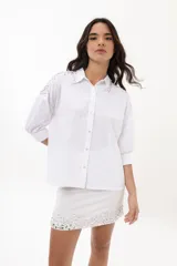 Falda blanca de lino y algodón, corte mini y bordado con lentejuelas plateadas en el ruedo.