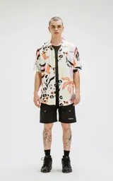 Camisa de manga corta con estampado abstracto multicolor, calce oversize y canesú en la espalda.