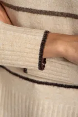Sweater color crema con rayas horizontales en tonos marrón, bordeaux y beige.