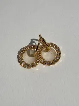 Par de aros colgantes dorados con forma de aro con strass y dije de resina transparente.
