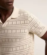 Remera polo de manga corta color crema, con cuello en V y textura patchwork.