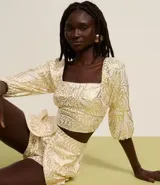 Blusa cropped de mangas 3/4, confeccionada en viscolino con 20% de lino, con escote cuadrado, elásticos en las sisas y puños. Prenda con estampa abstracta de foil.