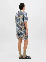 Short de baño con estampado abstracto en tonos celeste, marrón, beige y gris. Tiene cintura elástica con cordón ajustable, bolsillos laterales y un bolsillo trasero.