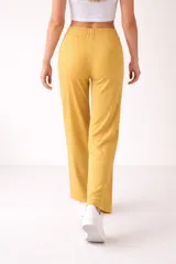 Pantalón de viscosa color amarillo mostaza, de corte ancho y tiro alto, con cintura elástica y cordón ajustable. Presenta un diseño acanalado.