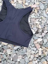 Top deportivo negro con cuello alto y espalda deportiva.