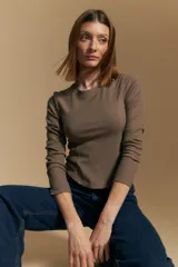 Remera de manga larga color marrón topo, con cuello redondo y tejido acanalado. Presenta costuras curvas que definen la silueta al cuerpo.