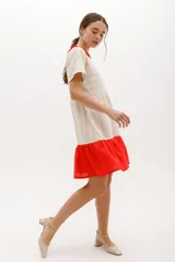 Vestido corto color beige con rayas horizontales, cuello redondo con volados rojos y falda roja.