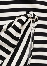 Vestido largo de fiesta con estampado de rayas diagonales en blanco y negro, escote asimétrico y tirante ancho con nudo.
