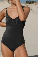 Traje de baño enterizo negro con textura acanalada, escote en V y breteles con argollas decorativas de resina.