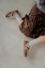 Championes acordonados color beige y dorado con suela marrón.