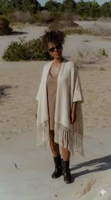 Ruana color crudo de tejido artesanal con flecos largos en el ruedo.