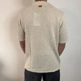 Camisa tejida de manga corta color verde oliva, con cuello tipo polo y cierre frontal con botones.