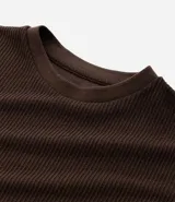 Remera masculina de manga corta, cuello redondo y textura acanalada, color beige claro.