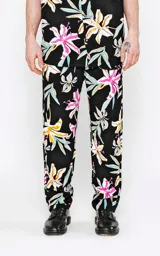 Pantalón recto de calce regular, color negro, con estampado de flores tropicales en tonos blanco, amarillo, rosado y celeste.