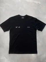 Remera negra de corte oversize con cuello redondo y manga corta. Presenta un estampado minimalista en blanco con el texto "FOCUS THE GOOD" y el logo "OSTEN" en el frente.