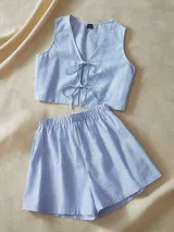 Conjunto de short y top a rayas azules y blancas. El top es sin mangas y tiene lazos en la parte delantera. El short tiene cintura elástica.