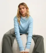 Blusa marrón de punto con cuello alto y manga larga.
