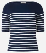 Blusa de punto con textura acanalada, escote barco y mangas 3/4. Diseño a rayas horizontales blancas y negras.