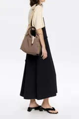 Bolso de mano negro de nailon con estructura blanda, doble asa de mano y asa de tejido regulable. Cuenta con logo metálico BIMBA Y LOLA, acabados metálicos, bolsillo interior, cierre de cordón e interior con etiqueta de tejido.