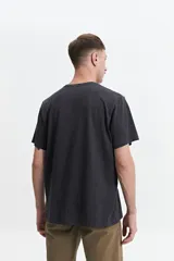 Remera negra de manga corta con estampado abstracto en tonos grises.