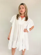 Vestido blanco de corte suelto, con escote en V y mangas cortas con detalles bordados.