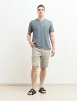 Remera manga corta con cuello redondo y tapeta con dos botones.