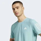 Remera deportiva Adidas Own The Run color celeste con cuello redondo y mangas cortas. Presenta el logo de Adidas en el pecho y las tres tiras características de la marca en las mangas.