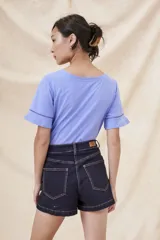 Remera blanca de algodón con cuello redondo y mangas cortas con volado y detalle de puntilla calada.