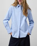 Camisa celeste de algodón con rayas verticales, manga larga, cuello clásico con cierre de botón, botonadura frontal oculta y canesú con pliegue en la espalda.